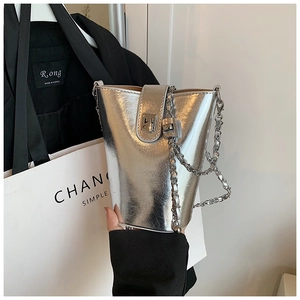 Détail du sac seau argenté à effet miroir avec bandoulière chaîne et fermoir tournant