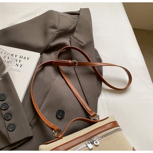 Détail du sac en toile tissée avec garniture en cuir marron et fermeture éclair métallique