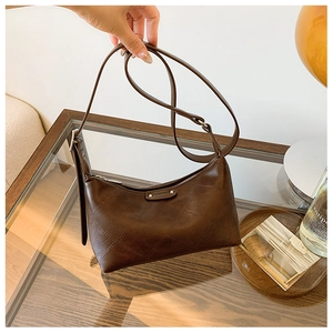 Detail of coffee brown moon bag with quilted leather texture and silver zipper detail