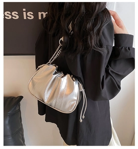 Detail of silver pleated cloud bag with metallic finish and delicate chain shoulder strap