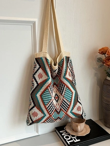 Bohemian geometric knit tote bag with diamond patterns hanging on a white vintage door