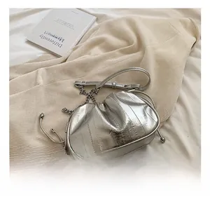 Close-up of silver pleated cloud bag with metallic chain strap and drawstring detail