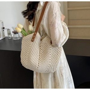 Detail of hand-woven cream shoulder bag with brown leather strap and X-stitch sewing