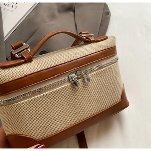 Détail du sac à main en toile avec bordure en cuir marron et fermeture éclair en métal
