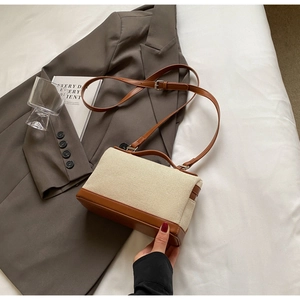 Détail du sac cabas rétro en toile avec finitions en cuir marron et poignée