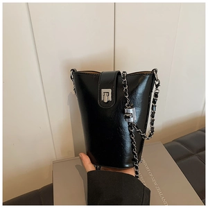 Sac seau minimaliste en PU noir avec finition brillante et bandoulière chaîne argent