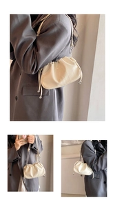 Detail view of beige ruched cloud bag with silver chain strap and drawstring closure