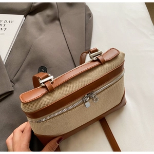Détail d'un sac à main vintage en toile avec bordure en cuir et fermetures éclair