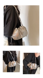 Close-up of metallic silver pleated cloud bag with elegant chain strap and drawstring