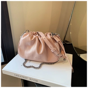 Close-up of pink ruched cloud bag with silver chain strap and embossed leather logo
