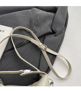 Detail of adjustable thin cream PU leather shoulder strap with silver buckle hardware