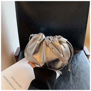 Close-up of metallic silver pleated cloud bag featuring glossy texture and sleek strap