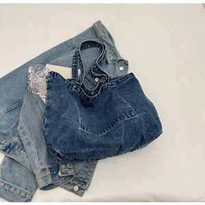 Detailed view of large dark blue denim tote bag with vintage wash and pocket stitching