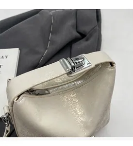 Detail of cream white bucket bag showing textured finish and silver twist lock