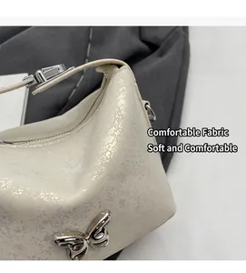 Close-up of cream bucket bag showing pearlescent cracked texture and silver butterfly