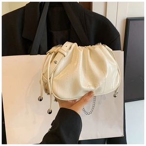 Detail of cream pleated cloud bag with metallic silver bead drawstring and chain strap