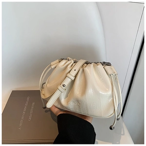 Detail of the cream-colored pleated cloud bag with shiny leather texture and silver chain