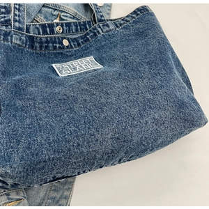 Close-up of denim tote bag with 7STREET 6LANE embroidery and metallic snap button