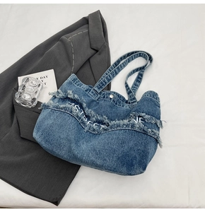 Détail du cabas en jean bleu foncé avec franges en V et broderie 7STREET LINE