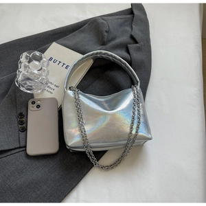 Detail of silver holographic handbag with chunky metal chain and padded handle