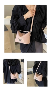 Detail of pink crossbody bag with silver butterfly clasp and textured finish