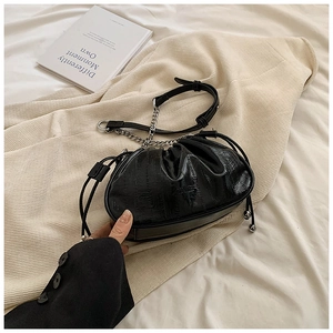 Detail of black glossy pleated cloud bag with silver chain and drawstring closure