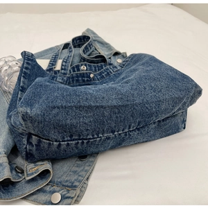 Flat lay of blue denim tote bag with washed fabric texture and spacious interior view