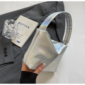 Macro detail of a silver holographic mini handbag with geometric folds and wide handle