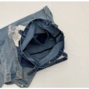 Internal view of large denim tote bag featuring an inner pocket and magnetic snap closure