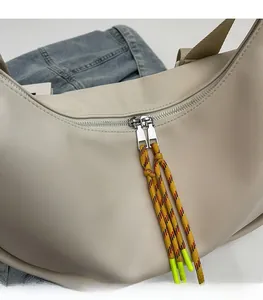 Détail de fermeture éclair fluide avec tirettes vert néon sur sac beige