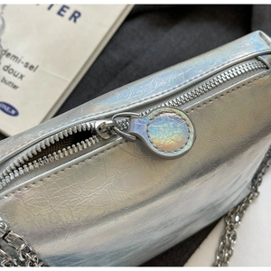 Close-up of the silver laser textured chain bag with smooth zipper and metallic finish