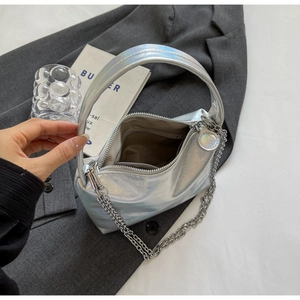 Detail view of silver handbag interior with zipper pocket and sleek metallic texture