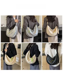 Vue détaillée des sacs à bandoulière croissants en argent et beige avec cordons néon