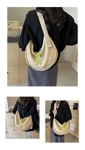 Détail du sac bandoulière beige en demi-lune avec cordon vert et logo embossé