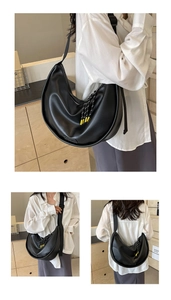 Détail du sac demi-lune noir avec tirette de zip tissée et large bandoulière réglable
