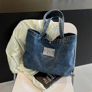 Large casual denim tote bag with 7STREET embroidery on a white chair setting