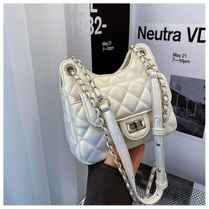 Détail macro du sac matelassé blanc avec fermoir rotatif argenté et bandoulière