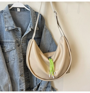 Détail du sac hobo beige montrant la tirette vert néon et la texture du cuir mat