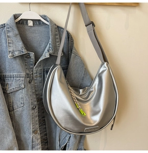 Détail du sac croissant argenté avec corde tressée et bandoulière grise réglable