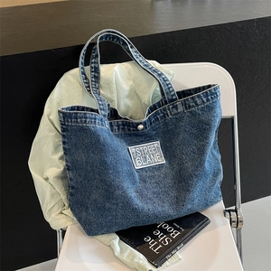 Retro deep blue denim tote bag with 7STREET 6LANE letter patch on a white chair