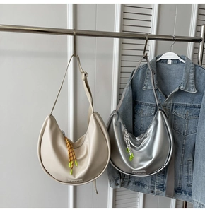 Détail du sac hobo avec pompon tissé coloré et bandoulière réglable pratique