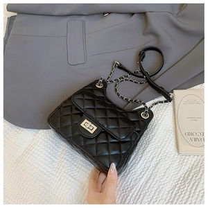 Détail du sac bandoulière en cuir matelassé noir avec fermoir rotatif argenté