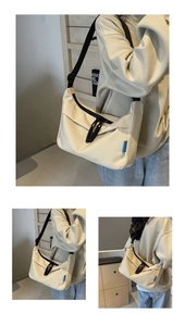 Detail of beige canvas dumpling bag featuring black adjustable strap and woven blue label