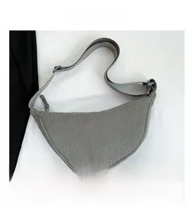 Close-up of grey corduroy crescent bag showing ribbed texture and adjustable strap