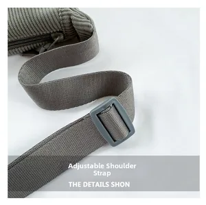 Detail showing the adjustable corduroy strap and plastic buckle of the crossbody bag