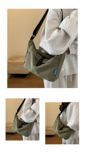 Detail of army green nylon crescent bag featuring black zipper and brand blue woven label