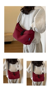 Macro shot of burgundy nylon shoulder bag with zipper detail and textured rope puller