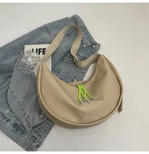 Détail du sac beige avec cordon de serrage vert fluo et étiquette en cuir JADU chic