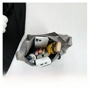 Interior view showing large capacity of grey corduroy crossbody bag with daily essentials