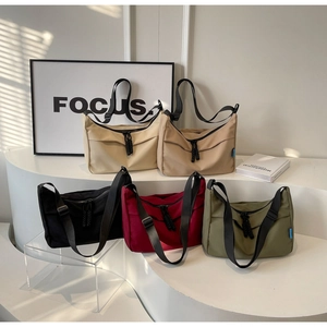 Detail view of five nylon crescent bags in various colors with adjustable wide straps